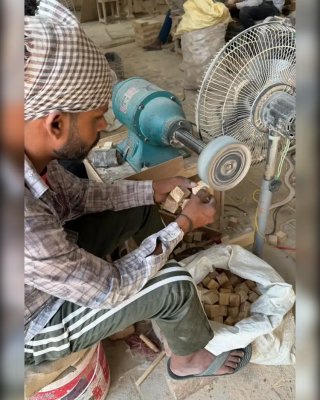 Worker Polishing Wooden Products at Workshop